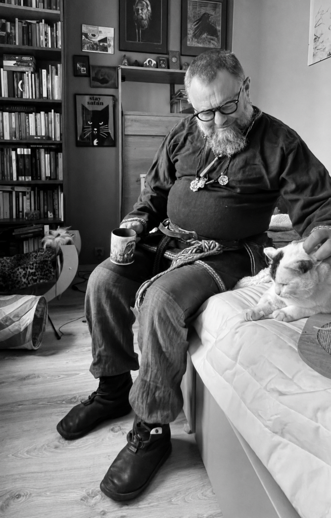 Zawisza petting his cat in his Warsaw apartment in Grochów