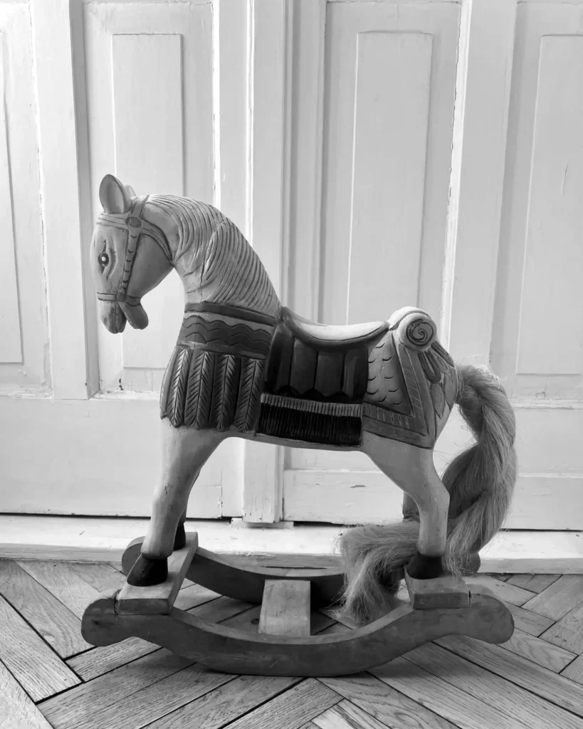 Handmade carved and painted wooden rocking horse in a lived-in Kamionek apartment