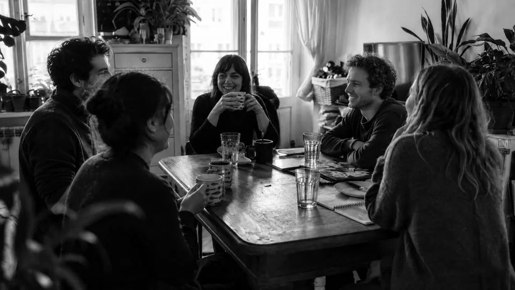 Guests sharing coffee around a table in a lived-in Warsaw home
